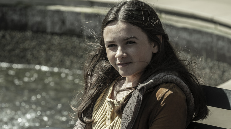 Judith sitting on a bench by the water