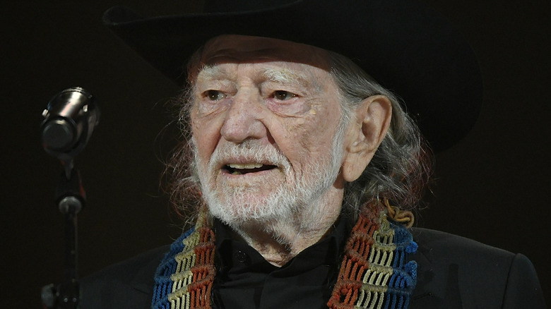 Willie Nelson smiling at microphone