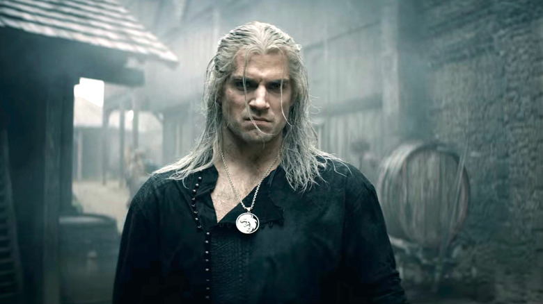 Geralt standing near a barrel