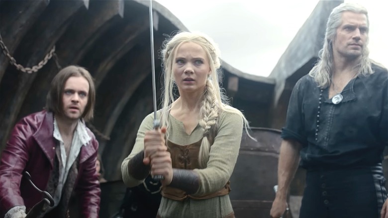 Jaskier, Ciri with sword, and Geralt on a ship