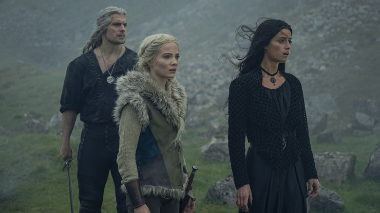 Geralt, Ciri, Yennefer standing around rocks