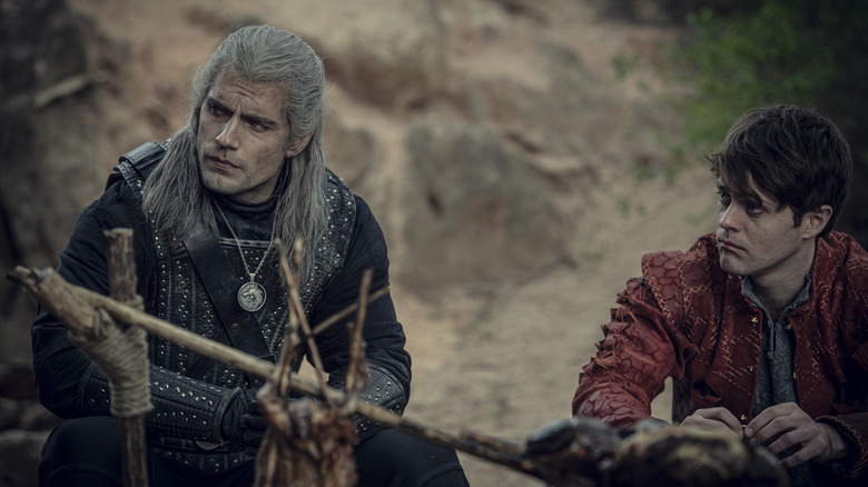 Geralt and Jaskier sitting next to each other