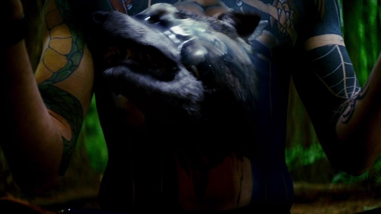 A wolf comes to life out of a tattoo