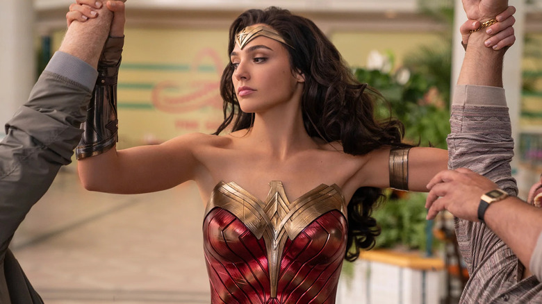 Wonder Woman holding two men's arms