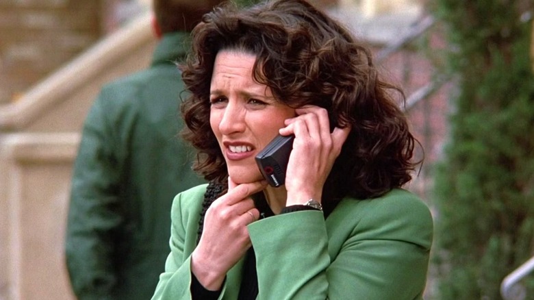 Elaine on the phone frowning