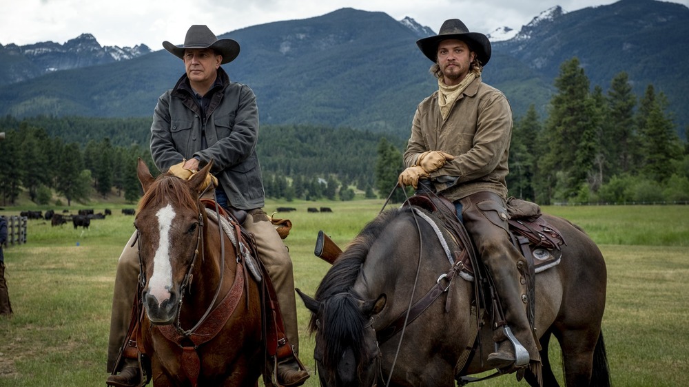 John Dutton (Kevin Costner) and Kayce Dutton (Luke Grimes) ride horses on Yellowstone