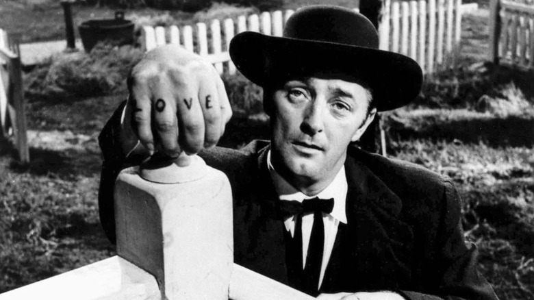 Reverend Harry Powell showing his knuckle tattoos