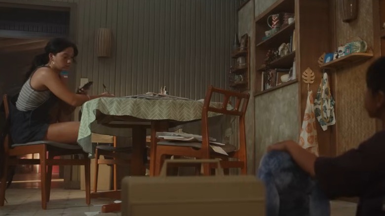 Nani doing chores at table while Lilo demonstrates Stitch's record-playing trick