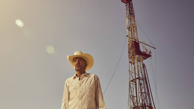 Tommy stands before an oil rig in "Landman"
