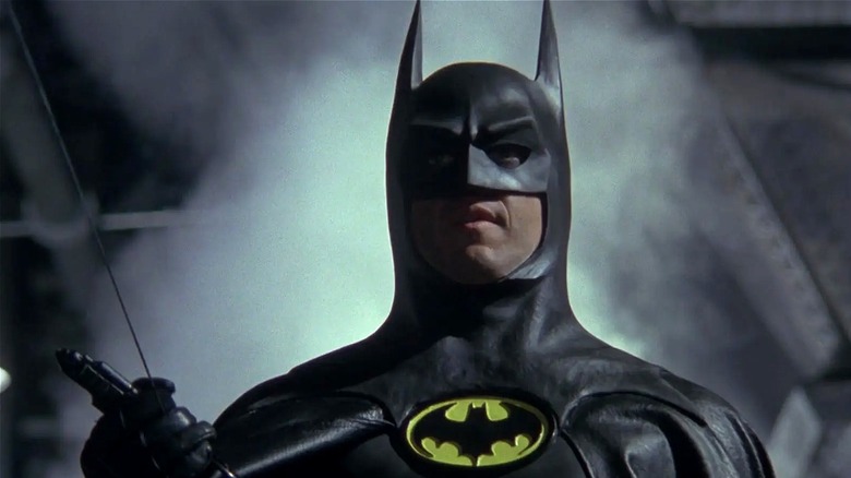 Batman holding onto his zipline tool