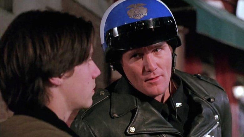 A man in a police uniform listens skeptically to Max