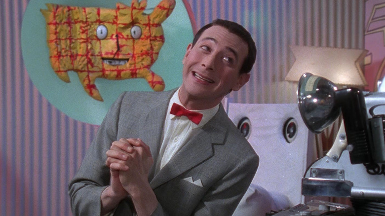Pee-Wee clasps his hands and smiles