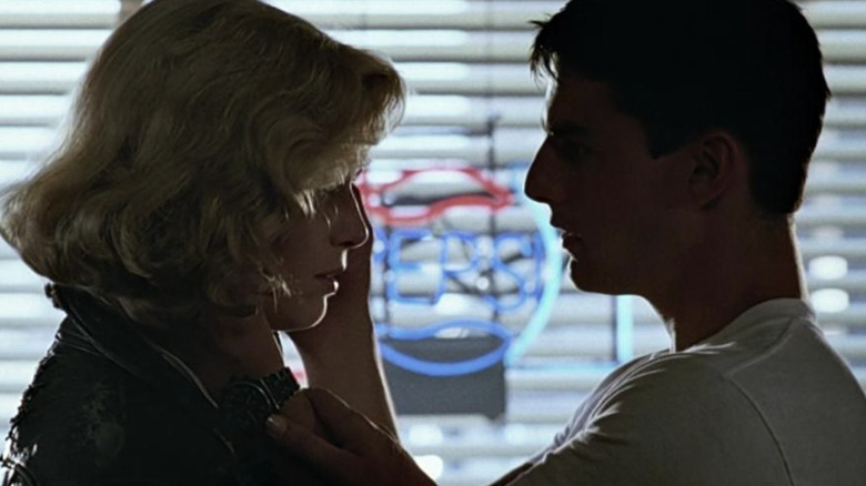 Tom holds Kelly McGillis' face