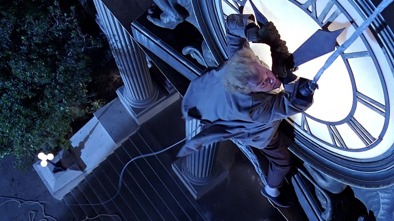 Doc Brown dangles from clock