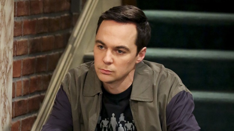 Sheldon sitting on stairs frowning