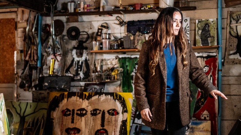 Tabitha looking at paintings in From