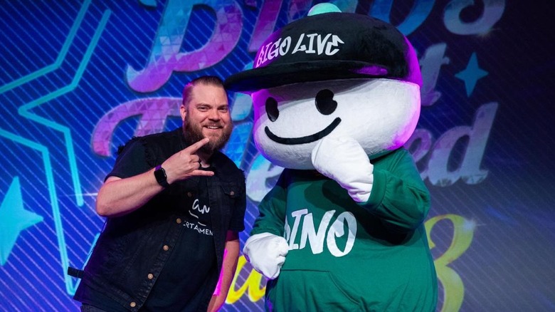 Guitar God posing with Bigo mascot