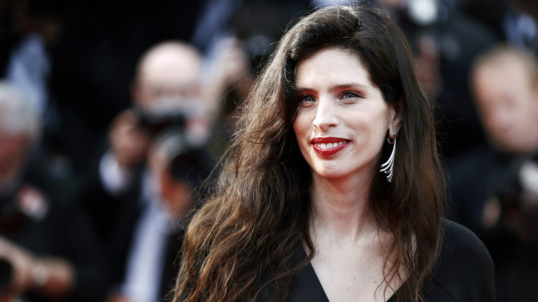 Maïwenn wearing red lipstick and black top