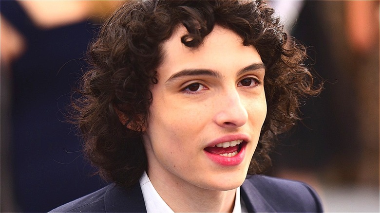 Finn Wolfhard talking in suit