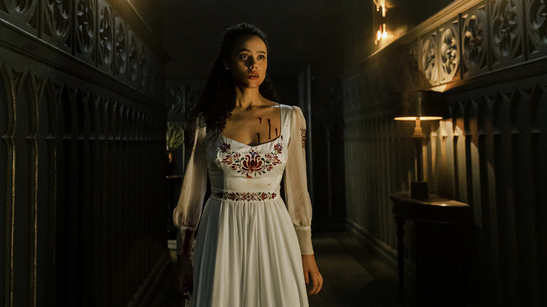 Evie wearing a white dress in hallway in The Invitation