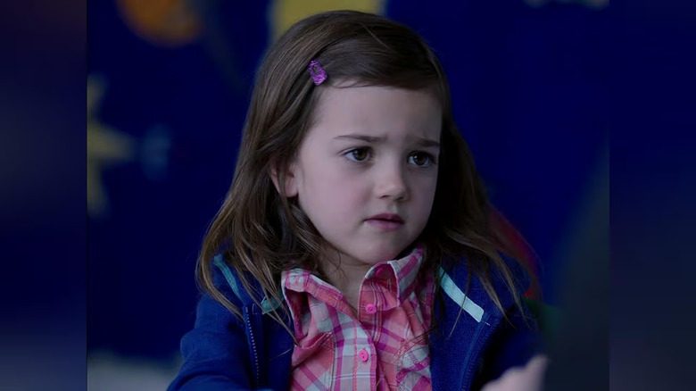 Harper Weil standing in front of blue bulletin board