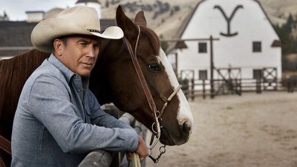 John Dutton stands with his horse