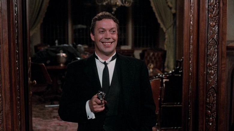 Wadsworth grinning and holding a gun in Clue