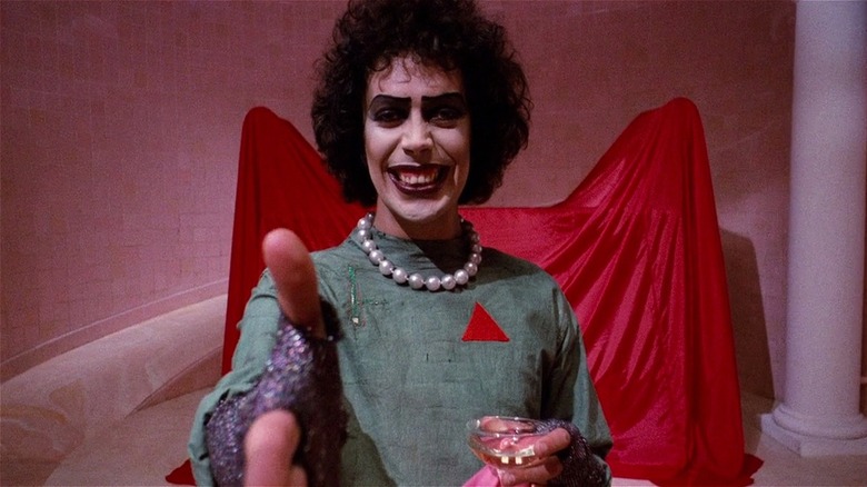 Dr. Frank-N-Furter putting his hand out for a shake