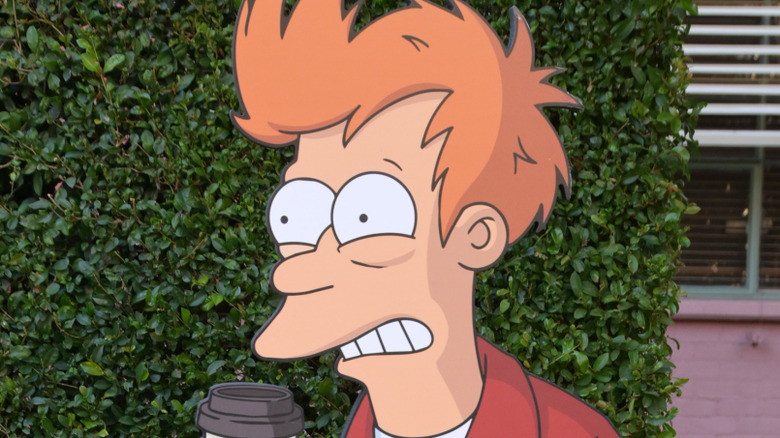 Fry frozen in a cryonic tube as aliens invade in the background in 