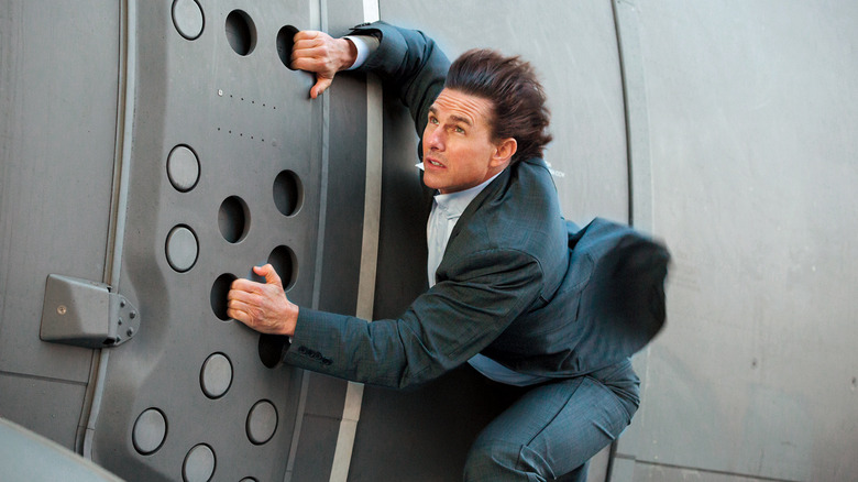 Tom Cruise hangs onto side of plane