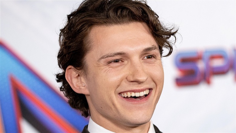 Tom Holland smiling for photographers