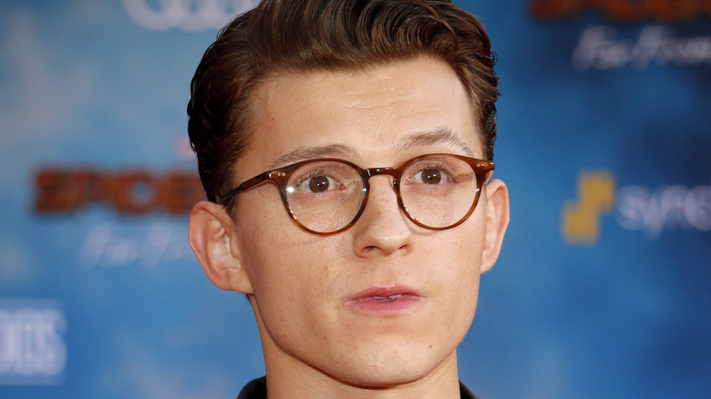 Tom Holland in glasses attends event 