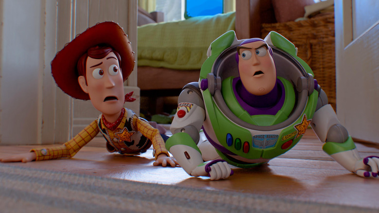 Woody and Buzz crawl out of a bedroom in 