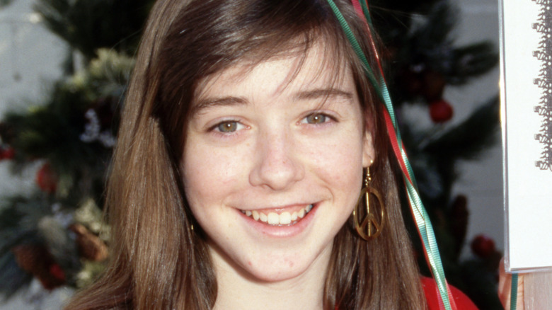 Alyson Hannigan posing at an event in 1989