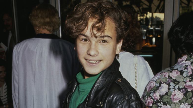 A young Johnny Galecki turns and smiles