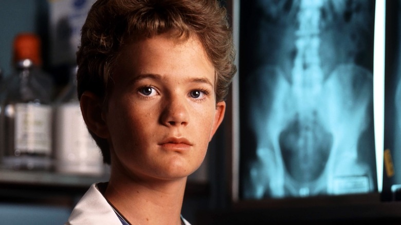 Doogie Howser, M.D., in a lab coat in front of a hip x-ray