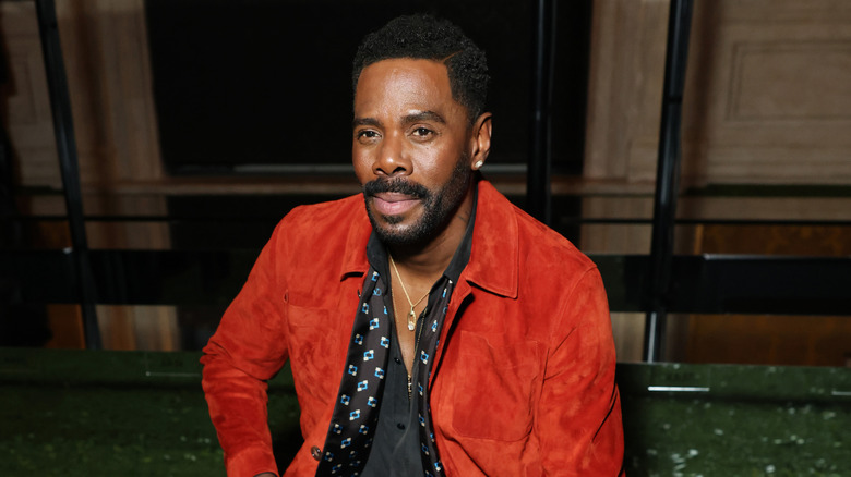 Colman Domingo sitting in a red suede jacket