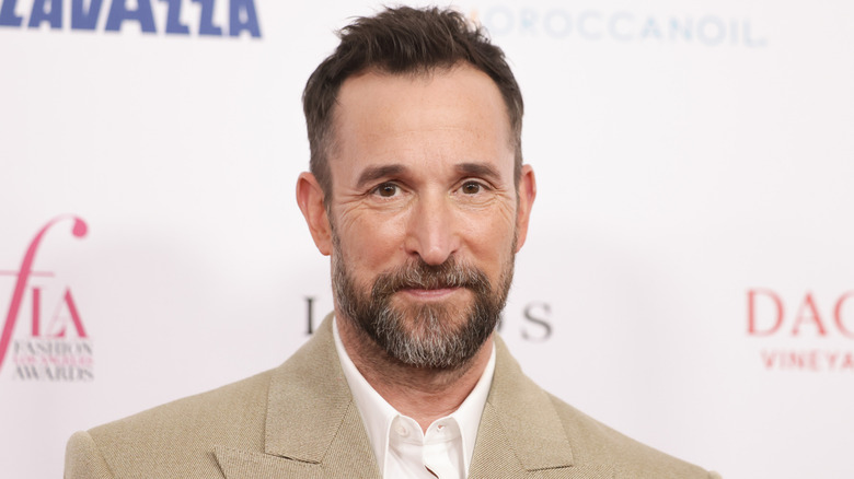 Noah Wyle wearing a tan suit