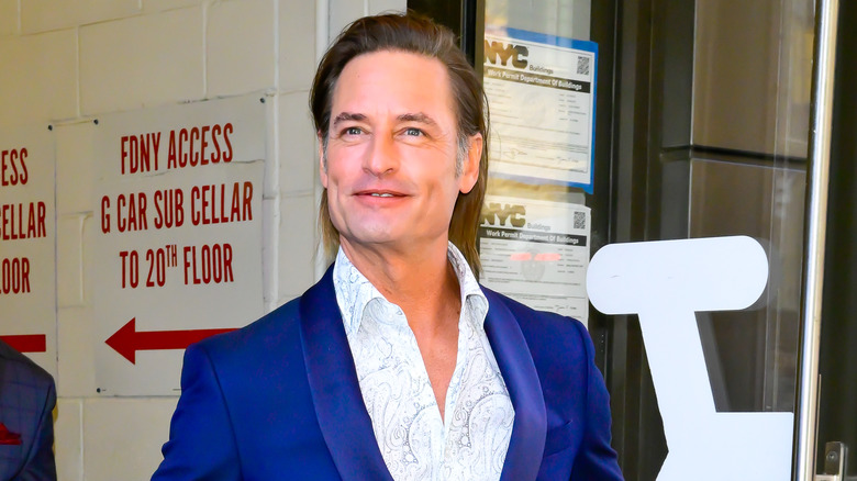 Josh Holloway smiles in a blue suit