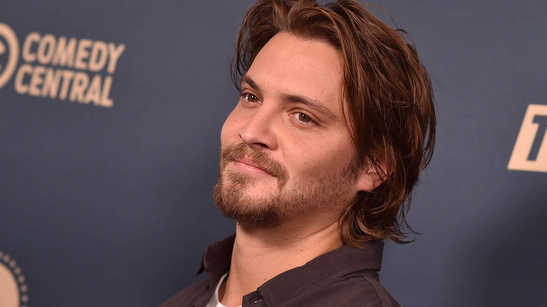 Luke Grimes smiles on the red carpet