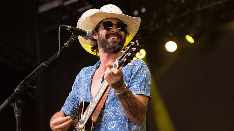 Ryan Bingham plays guitar on stage