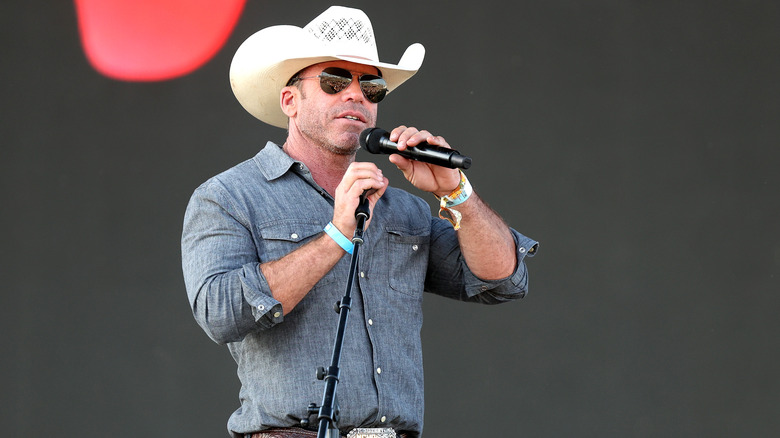 Taylor Sheridan speaks into a microphone on stage