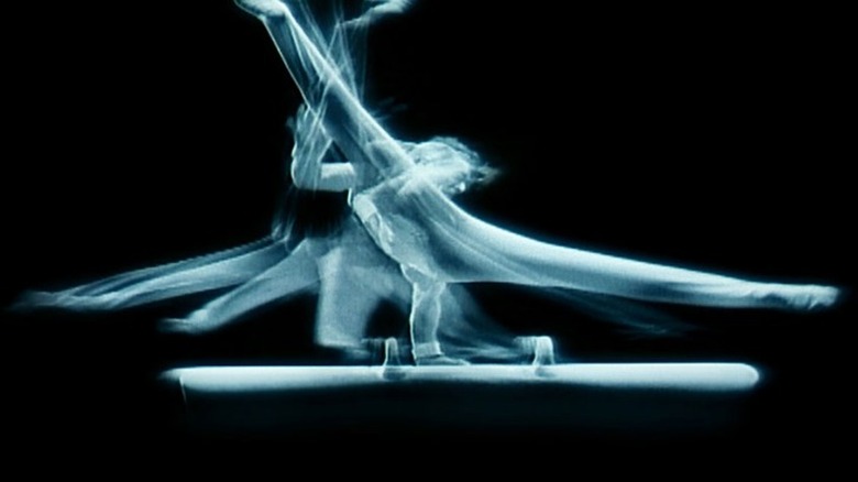 Superimposed images of a man performing a pommel horse routine in Naqoyqatsi (2002)