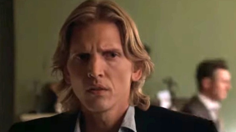 Tom Ripley looking to his left while Jeff Constant walks behind him in Ripley Under Ground (2005)