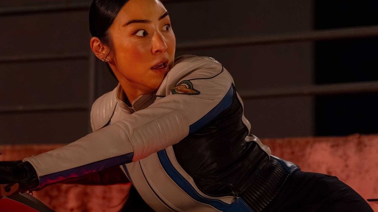 Eve looking back in terror while on a Light Cycle in Tron: Ares