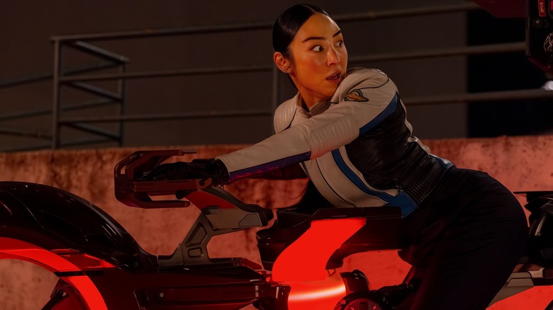 Eve Kim sitting on bike looking back nervously