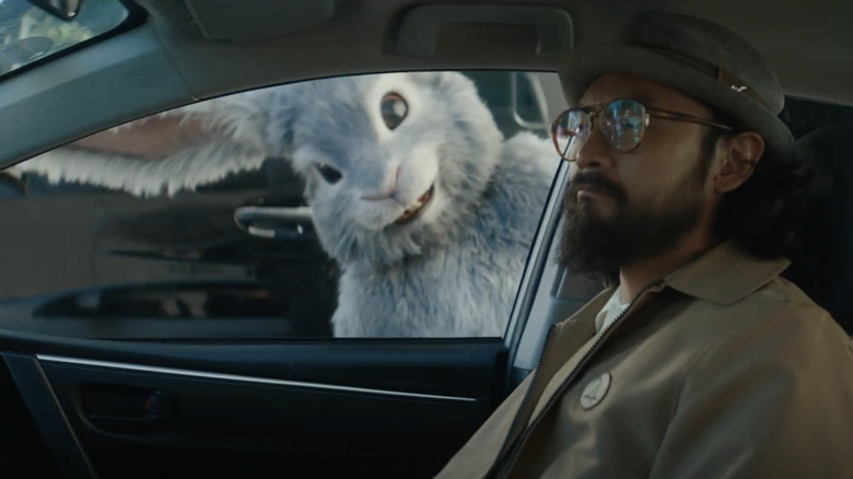 A giant bunny watches a man in a car