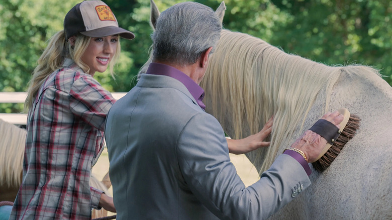 Dwight and Spencer brush a horse