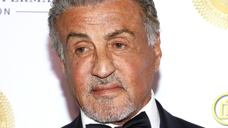 Sylvester Stallone wears a neutral expression