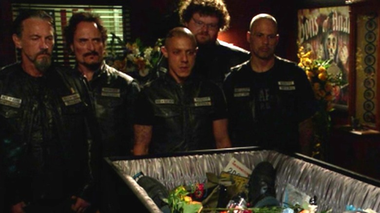 SAMCRO standing around a casket